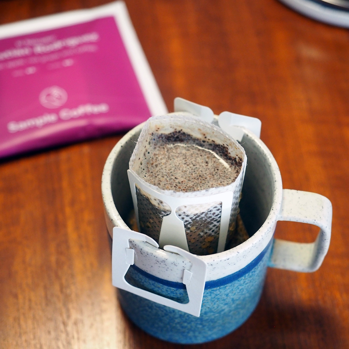 A cup brewing a coffee steeped bag.